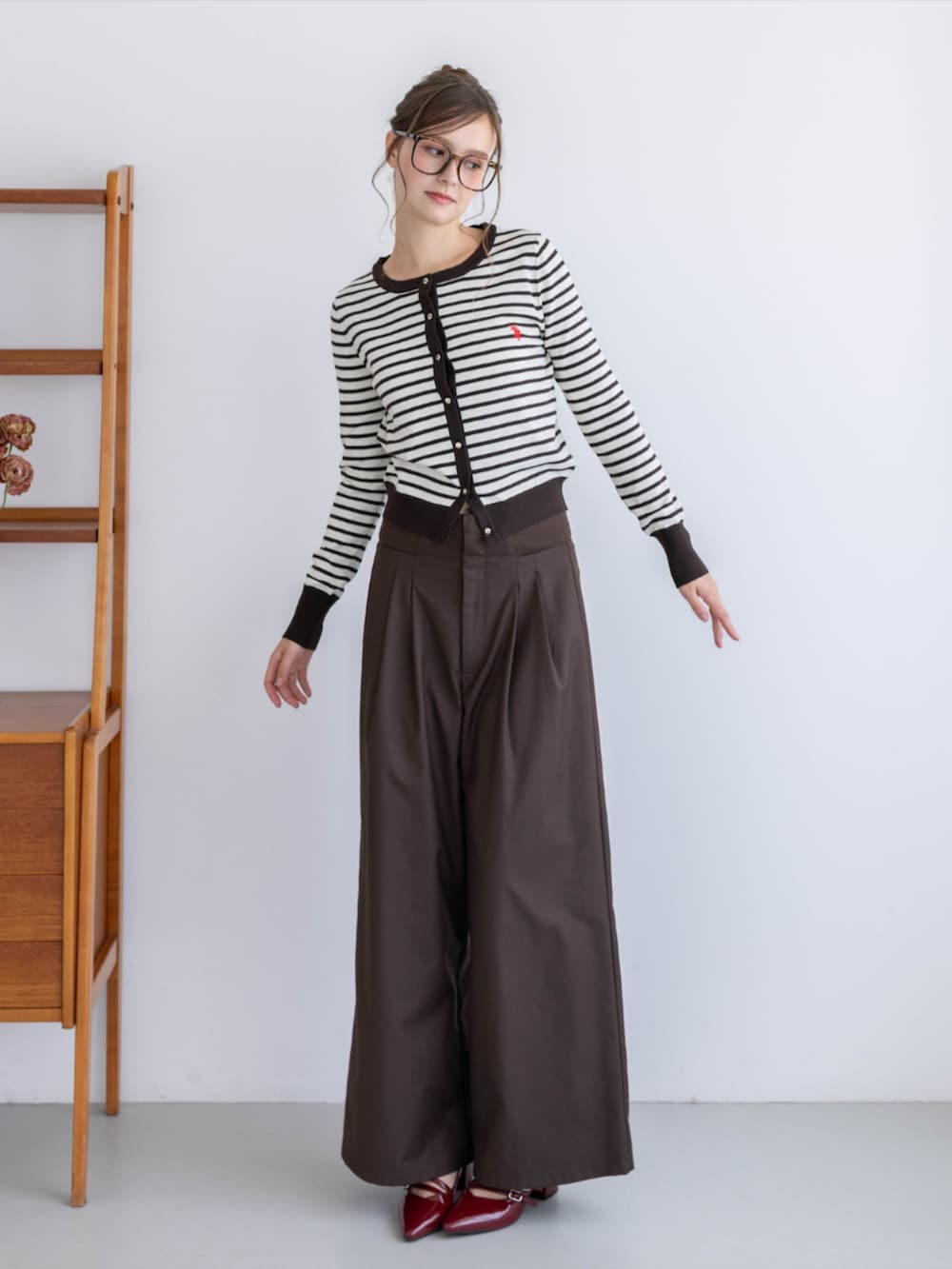 レッド系のパンプス、ブラウン系のスラックス、ブラウン系のカーディガン/ボレロを着用したレディースの夏コーディネートの6枚目の写真