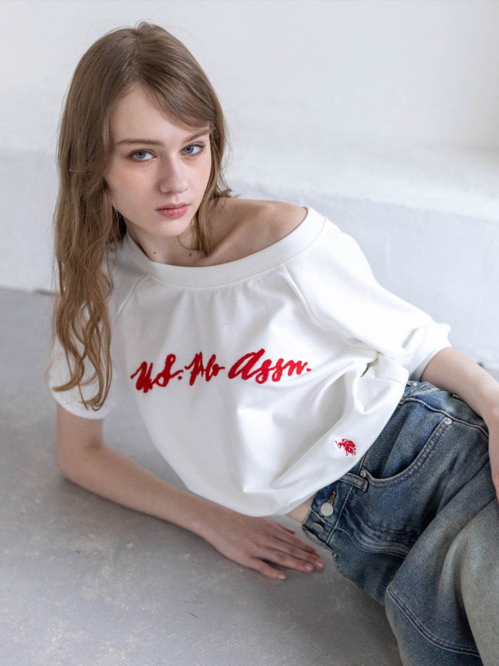 ブラック系のブーツ、ホワイト系のTシャツ/カットソー、ブルー系のデニムスカートを着用したレディースの夏コーディネートの6枚目の写真