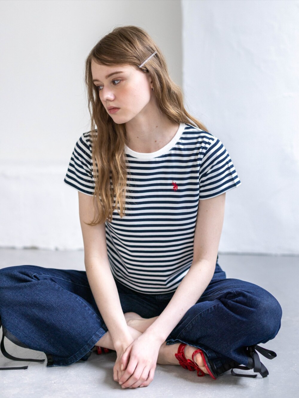 レッド系のサンダル、ブルー系のデニムパンツ、ホワイト系のTシャツ/カットソーを着用したレディースの夏コーディネートの5枚目の写真