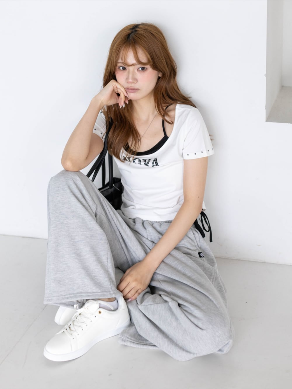 ゴールド系のスニーカー、グレー系のスウェットパンツ、ホワイト系のTシャツ/カットソーを着用したレディースの夏コーディネートの5枚目の写真