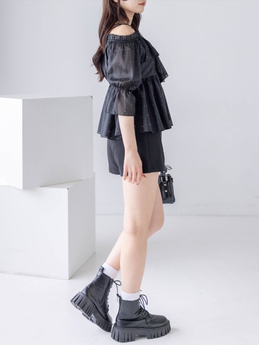 ブラック系のブーツ、ブラック系のその他パンツ、ブラック系のハンドバッグを着用したレディースの夏コーディネートの3枚目の写真