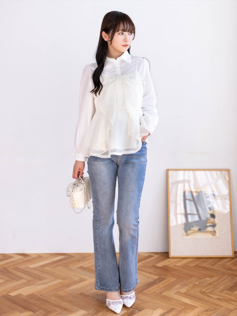 ブルー系のデニムパンツ、ホワイト系のシャツ/ブラウス、ホワイト系のパンプスを着用したレディースの春コーディネートの3枚目の写真