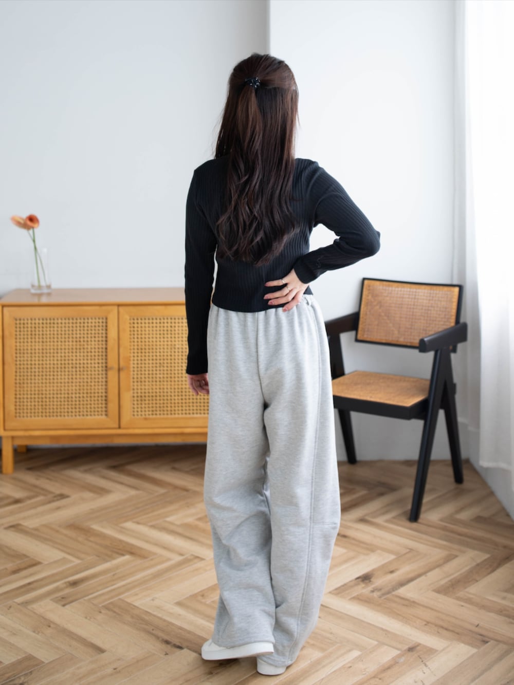 ゴールド系のスニーカー、グレー系のスウェットパンツ、ブラック系のTシャツ/カットソーを着用したレディースの夏コーディネートの2枚目の写真