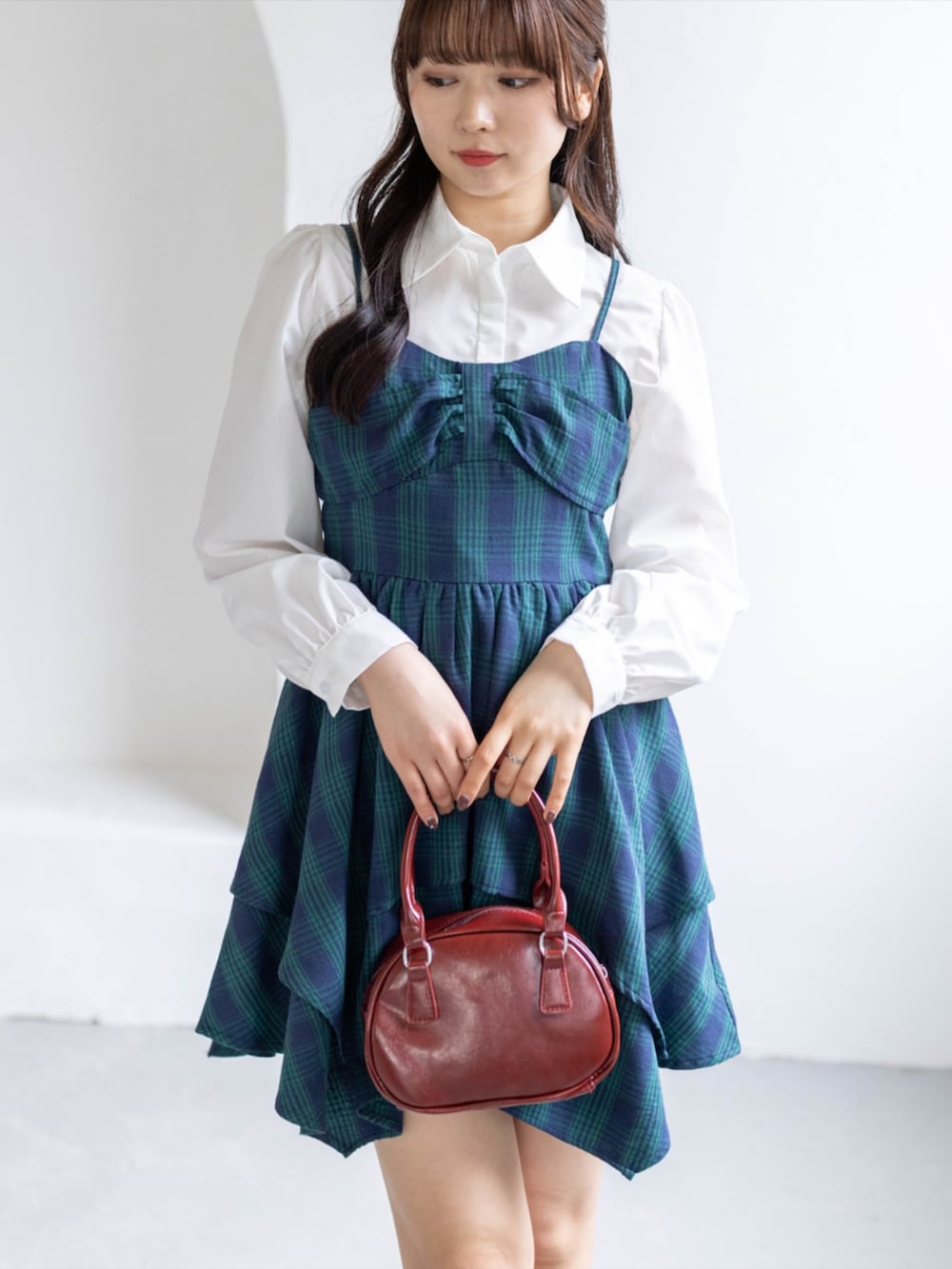 グリーン系のワンピース、ブラック系のブーツ、ホワイト系のシャツ/ブラウスを着用したレディースの春コーディネートの3枚目の写真