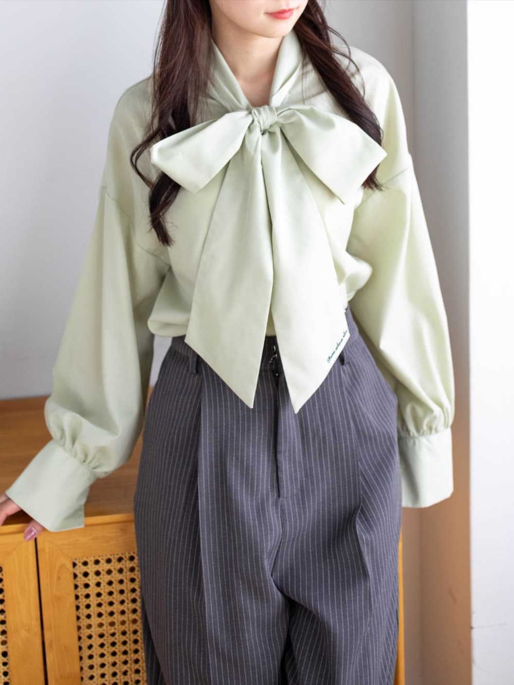 ブラック系のパンプス、グレー系のスラックス、グリーン系のシャツ/ブラウスを着用したレディースの夏コーディネートの6枚目の写真