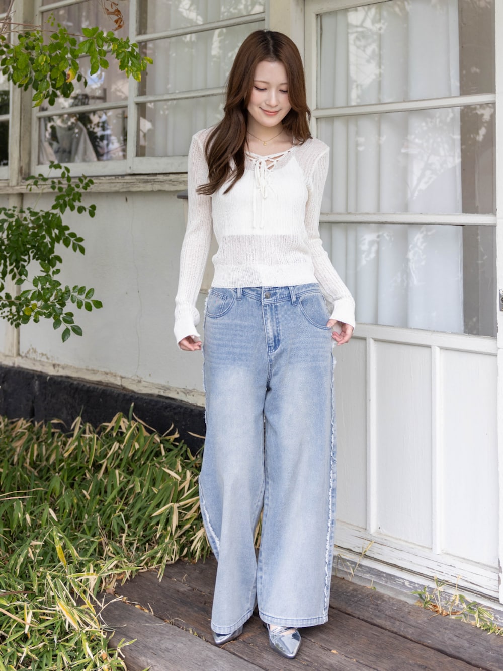 シルバー系のパンプス、ブルー系のデニムパンツ、ホワイト系のニット/セーターを着用したレディースの春コーディネートの3枚目の写真