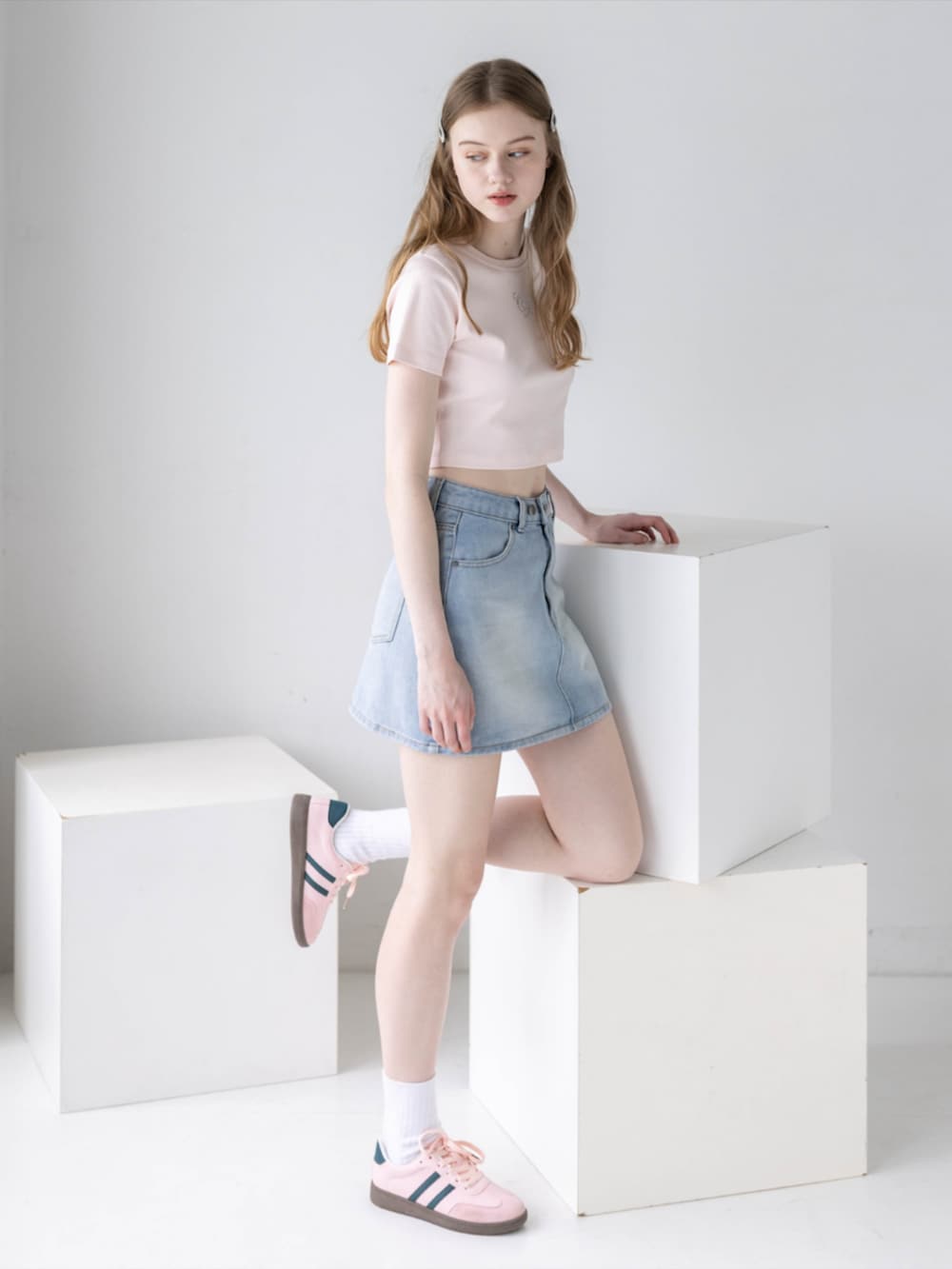 ピンク系のTシャツ/カットソー、ブルー系のデニムスカート、ピンク系のスニーカーを着用したレディースの夏コーディネートの2枚目の写真