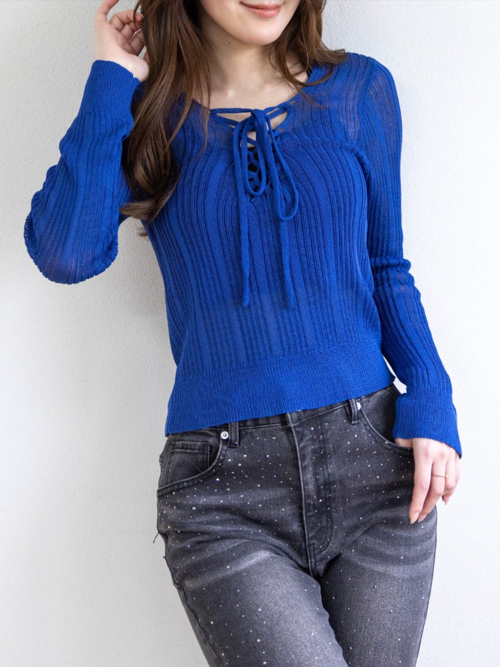 シルバー系のパンプス、ブラック系のデニムパンツ、ブルー系のニット/セーターを着用したレディースの春コーディネートの5枚目の写真