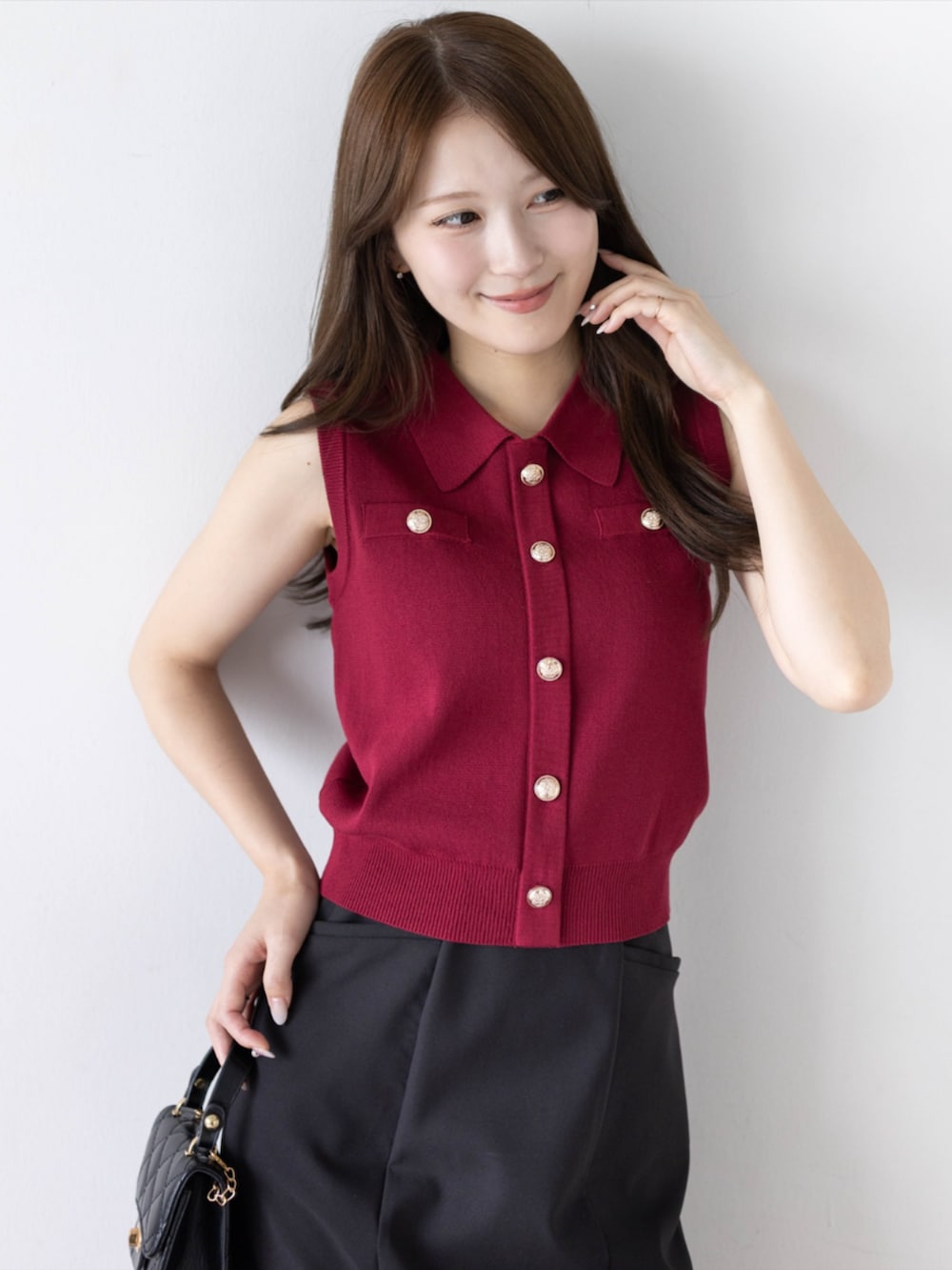 ブラック系のパンプス、ブラック系のスカート、レッド系のニット/セーターを着用したレディースの夏コーディネートの6枚目の写真