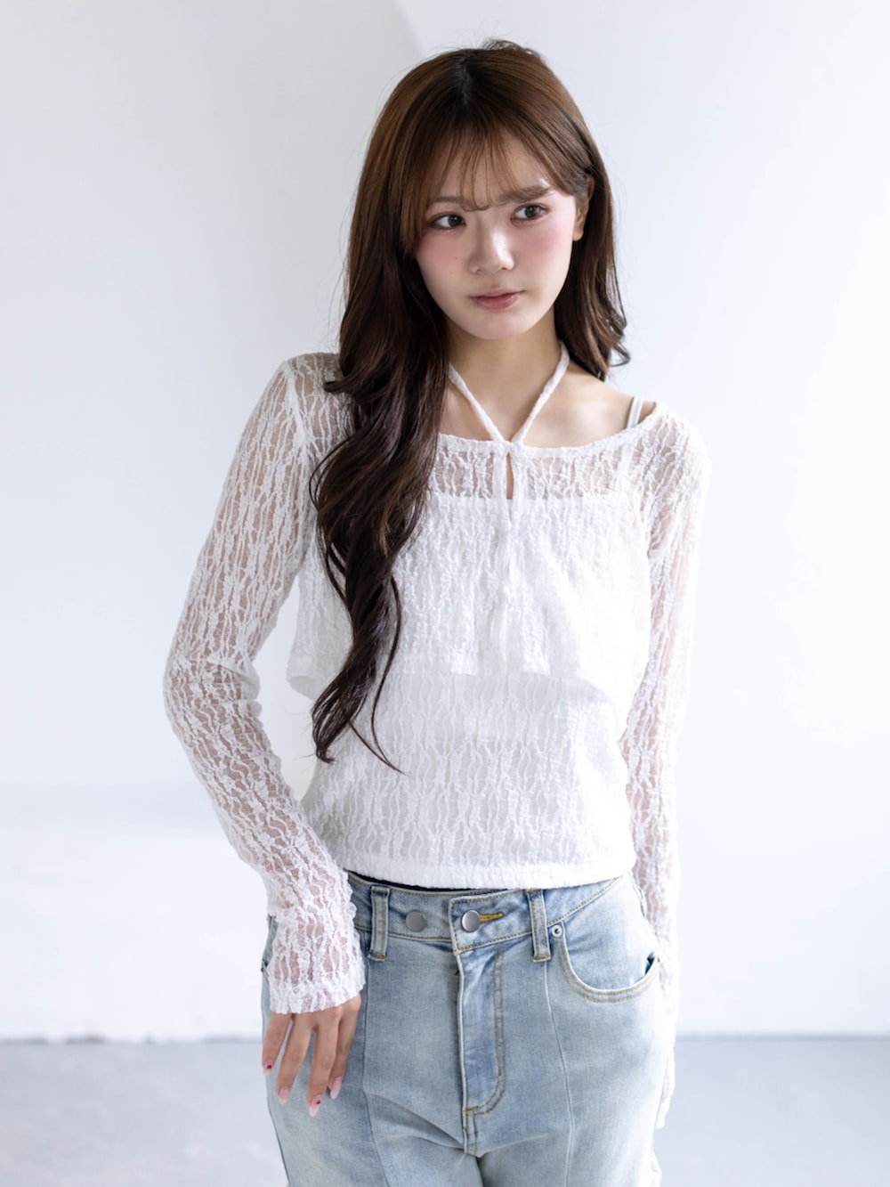 ホワイト系のパンプス、ホワイト系のカーディガン/ボレロ、ブルー系のデニムパンツを着用したレディースの春コーディネートの6枚目の写真