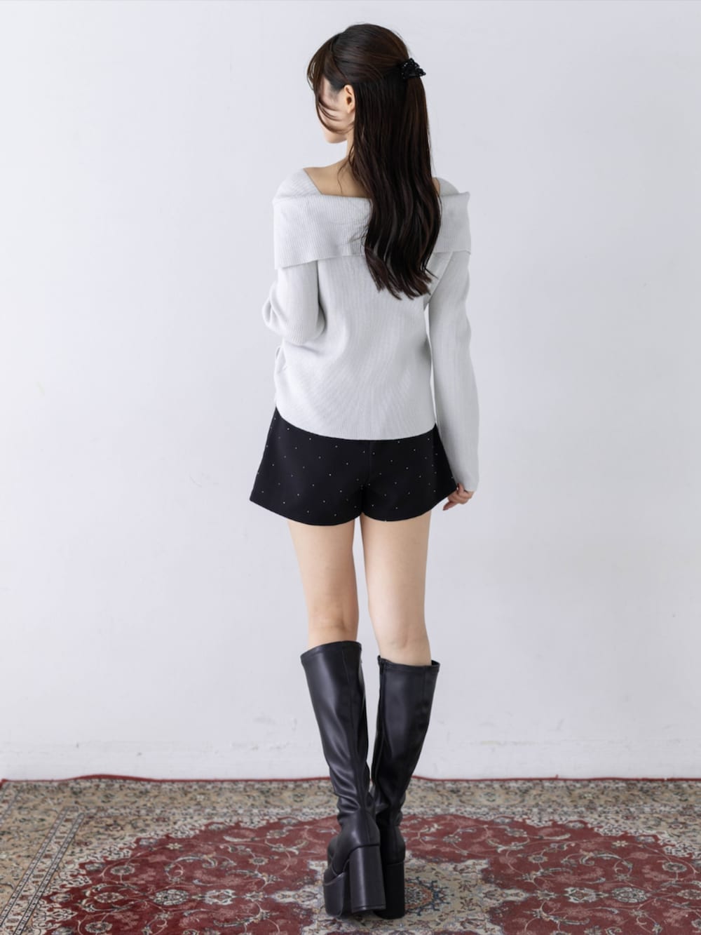 ブラック系のその他パンツ、ブラック系のブーツ、ホワイト系のニット/セーターを着用したレディースの秋コーディネートの2枚目の写真