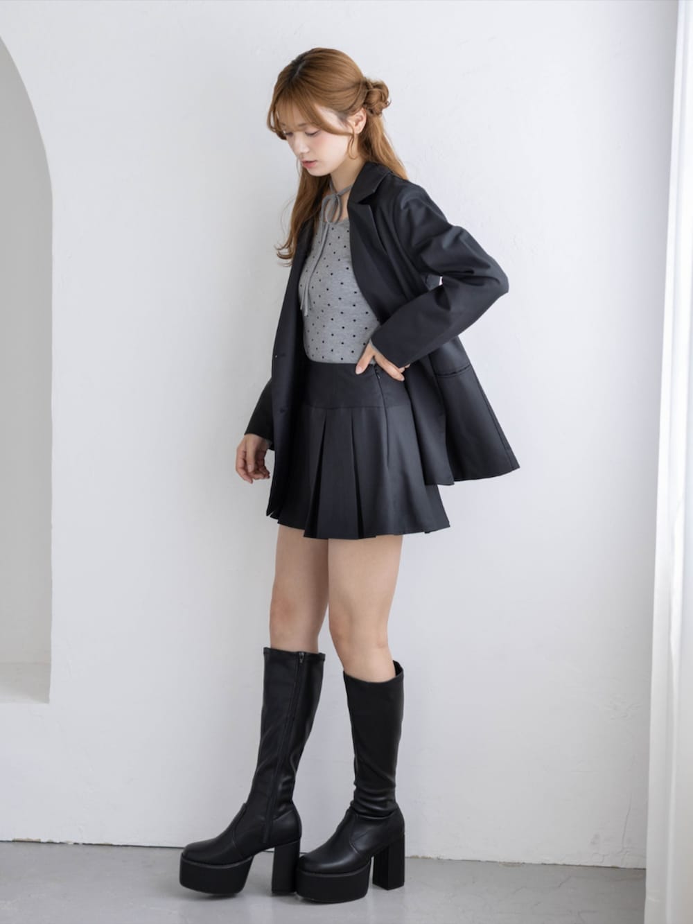 ブラック系のブーツ、グレー系のTシャツ/カットソー、ブラック系のスカートを着用したレディースの秋コーディネートの2枚目の写真