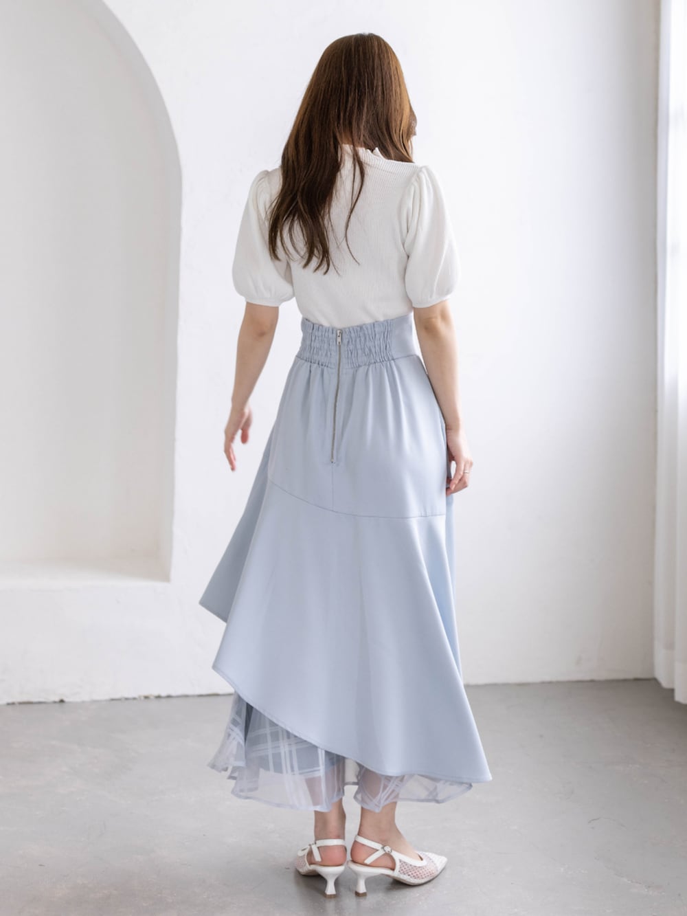 ホワイト系のパンプス、ブルー系のスカート、ホワイト系のニット/セーターを着用したレディースの春コーディネートの4枚目の写真