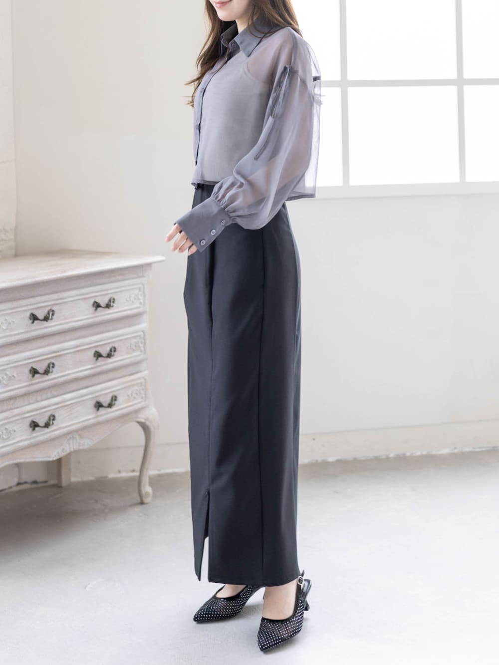 ブラック系のハンドバッグ、ブラック系のパンプス、ブラック系のスカートを着用したレディースの春コーディネートの4枚目の写真