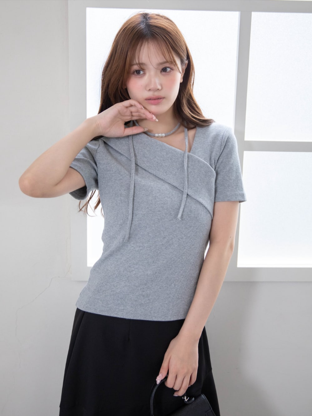 ブラック系のハンドバッグ、ブラック系のパンプス、グレー系のTシャツ/カットソーを着用したレディースの夏コーディネートの8枚目の写真