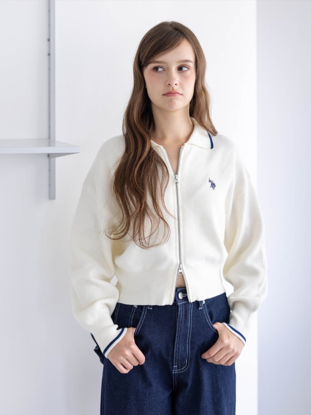 ゴールド系のスニーカー、ブルー系のデニムパンツ、ホワイト系のTシャツ/カットソーを着用したレディースの秋コーディネートの4枚目の写真