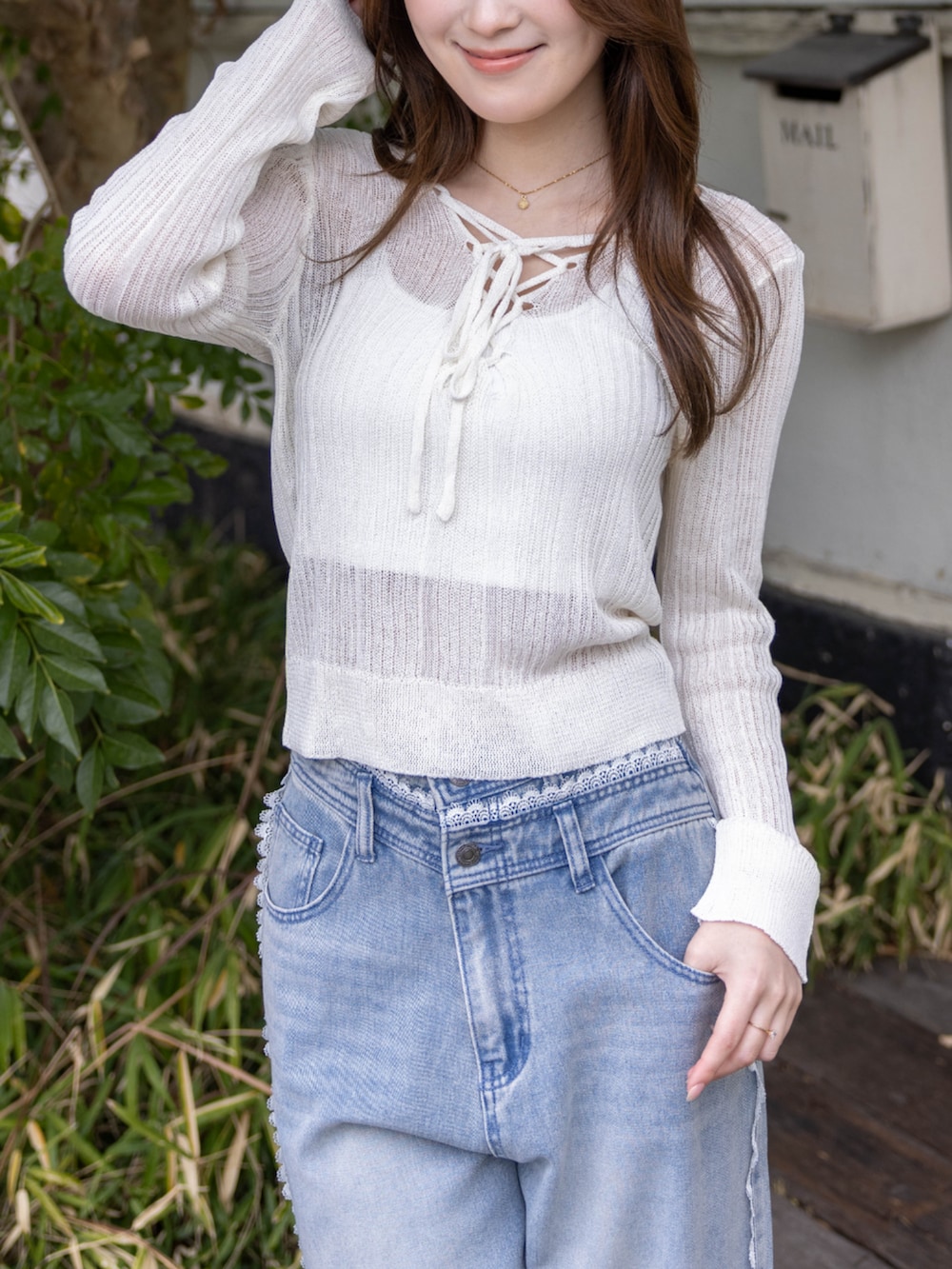 シルバー系のパンプス、ブルー系のデニムパンツ、ホワイト系のニット/セーターを着用したレディースの春コーディネートの7枚目の写真