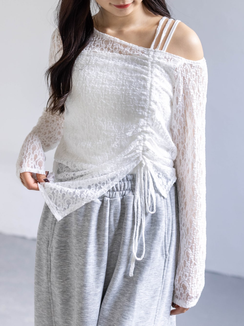 ホワイト系のスニーカー、グレー系のスウェットパンツ、ホワイト系のアンサンブルを着用したレディースの春コーディネートの4枚目の写真