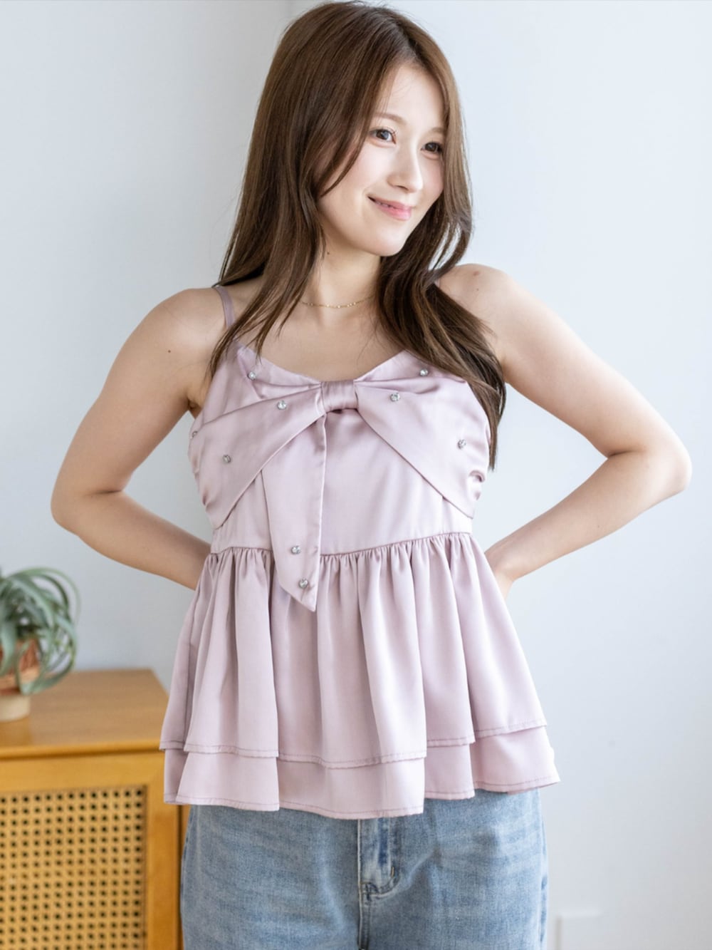 シルバー系のパンプス、ブルー系のデニムパンツ、ピンク系のキャミソールを着用したレディースの夏コーディネートの7枚目の写真