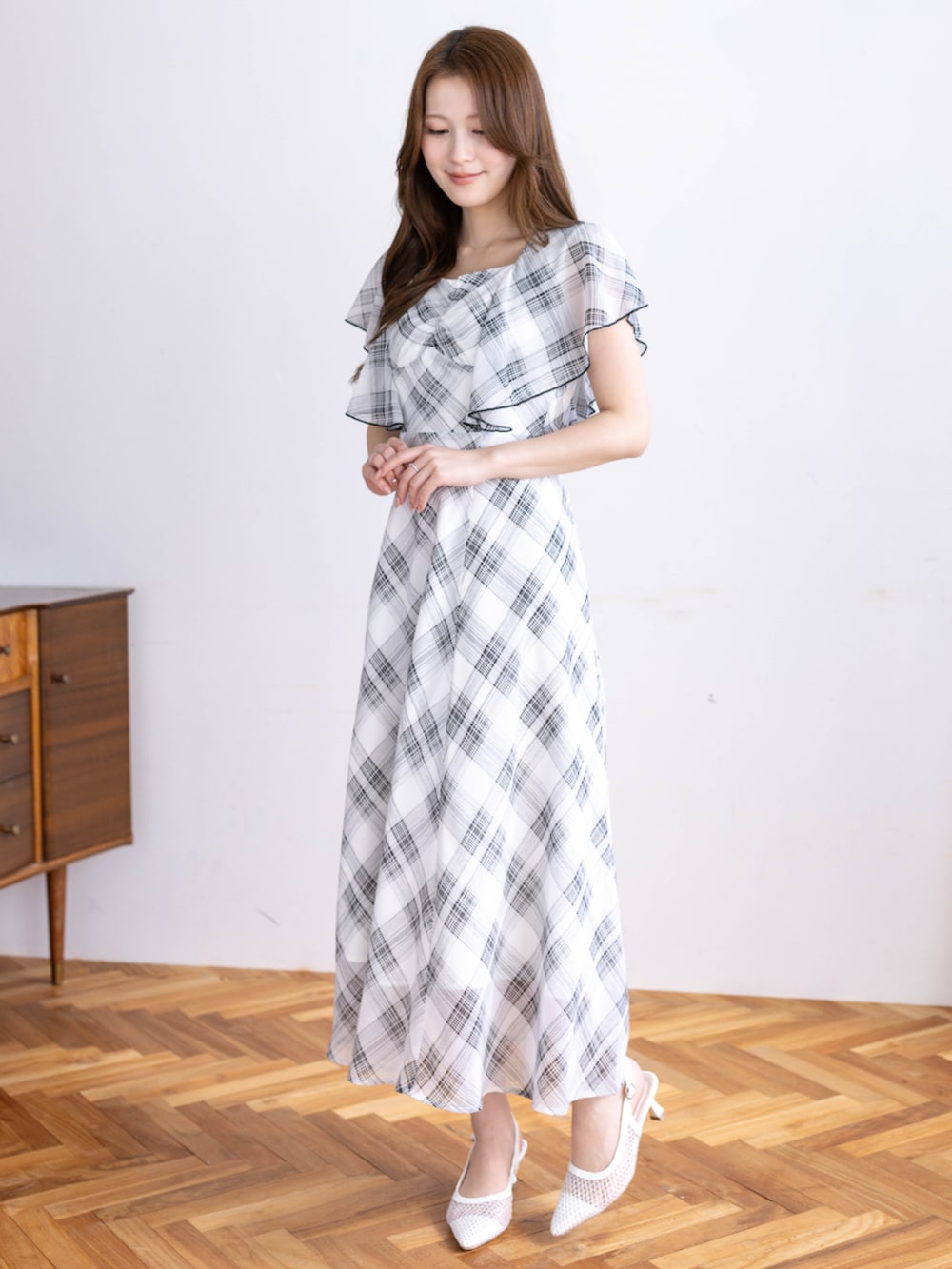 ホワイト系のパンプス、ホワイト系のワンピースを着用したレディースの春コーディネートの3枚目の写真