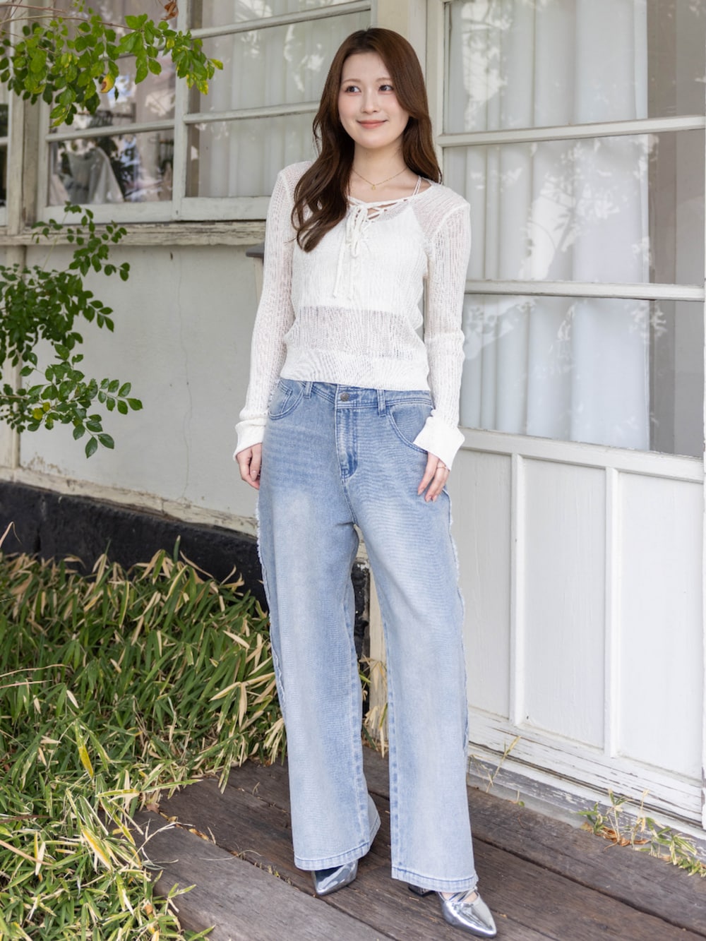 シルバー系のパンプス、ブルー系のデニムパンツ、ホワイト系のニット/セーターを着用したレディースの春コーディネートの2枚目の写真