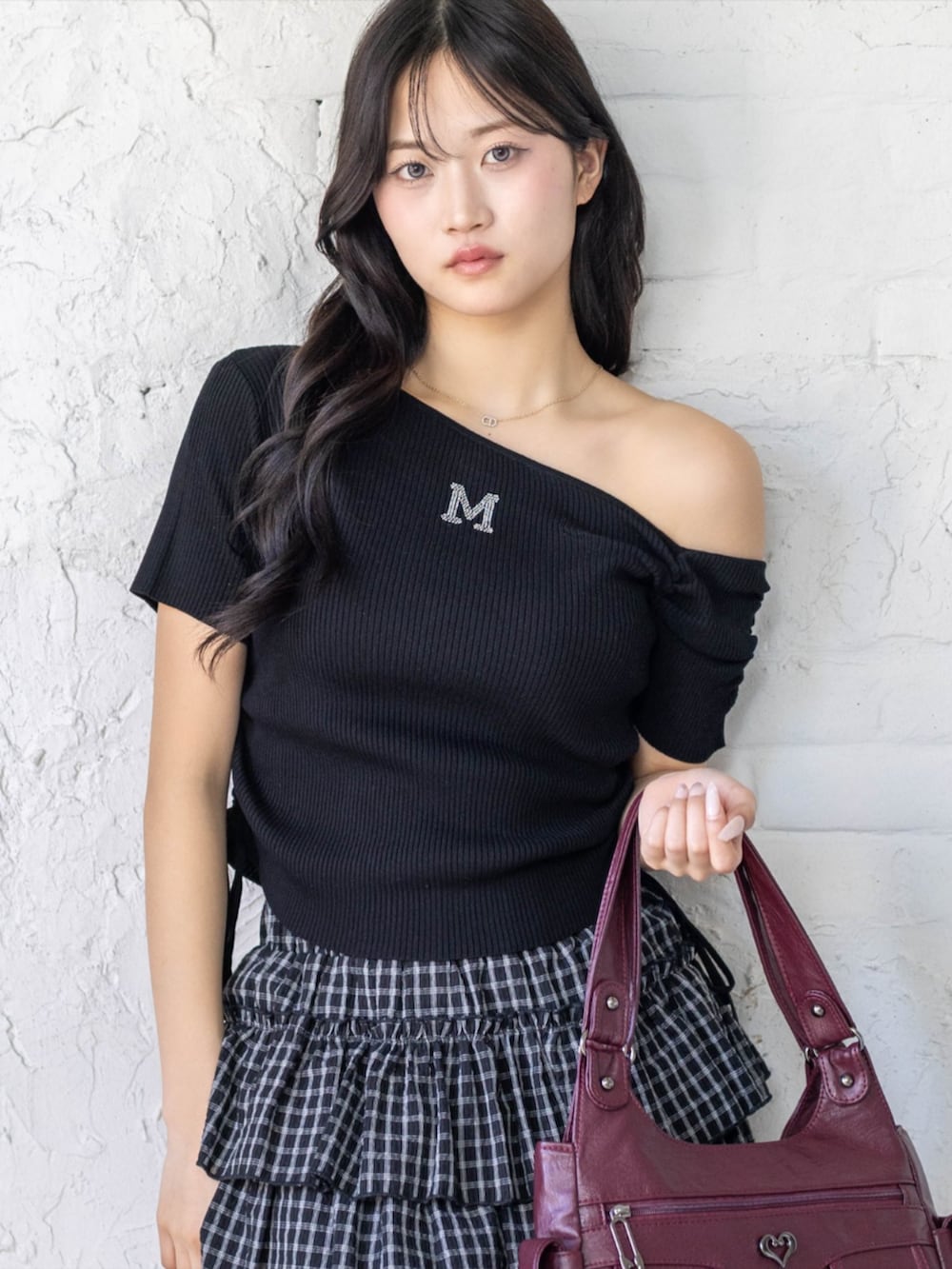 ブラック系のブーツ、ブラック系のスカート、ブラック系のニット/セーターを着用したレディースの春コーディネートの3枚目の写真