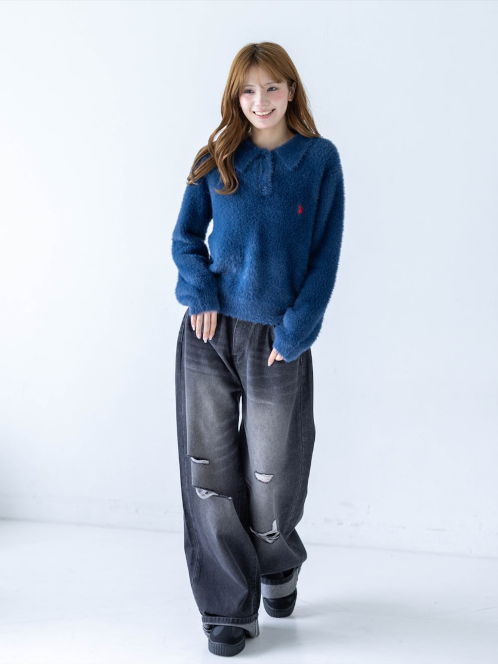 ブラック系のデニムパンツ、イエロー系のスニーカー、ブルー系のニット/セーターを着用したレディースの秋コーディネートの2枚目の写真