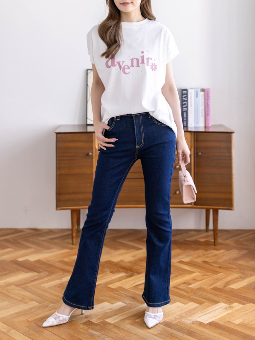 ブルー系のデニムパンツ、ホワイト系のパンプス、ホワイト系のTシャツ/カットソーを着用したレディースの春コーディネートの3枚目の写真