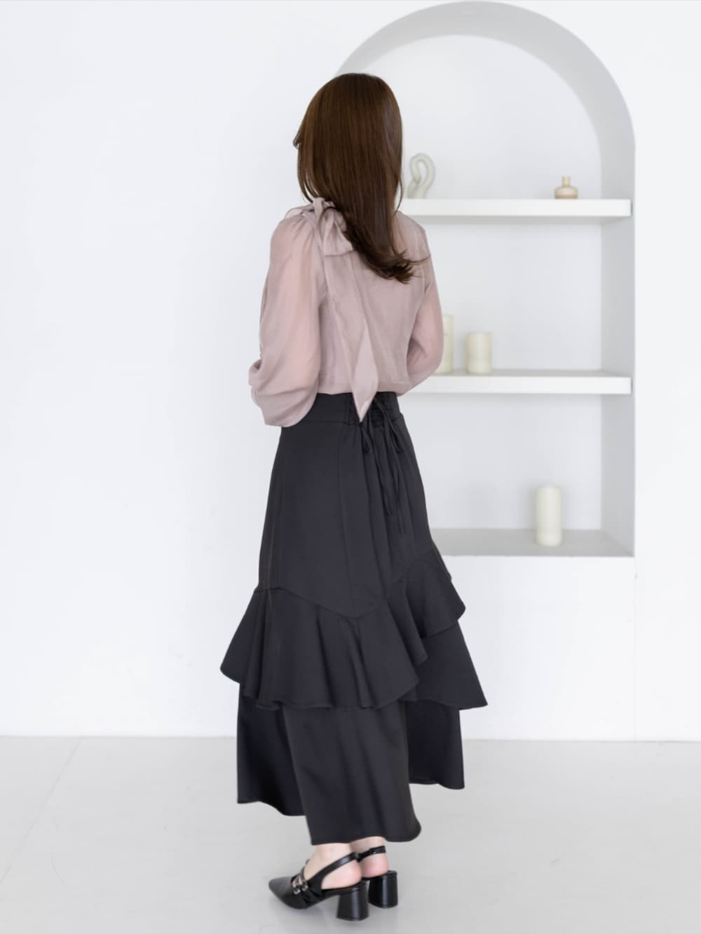 ブラック系のパンプス、ブラック系のスカート、ピンク系のシャツ/ブラウスを着用したレディースの夏コーディネートの3枚目の写真