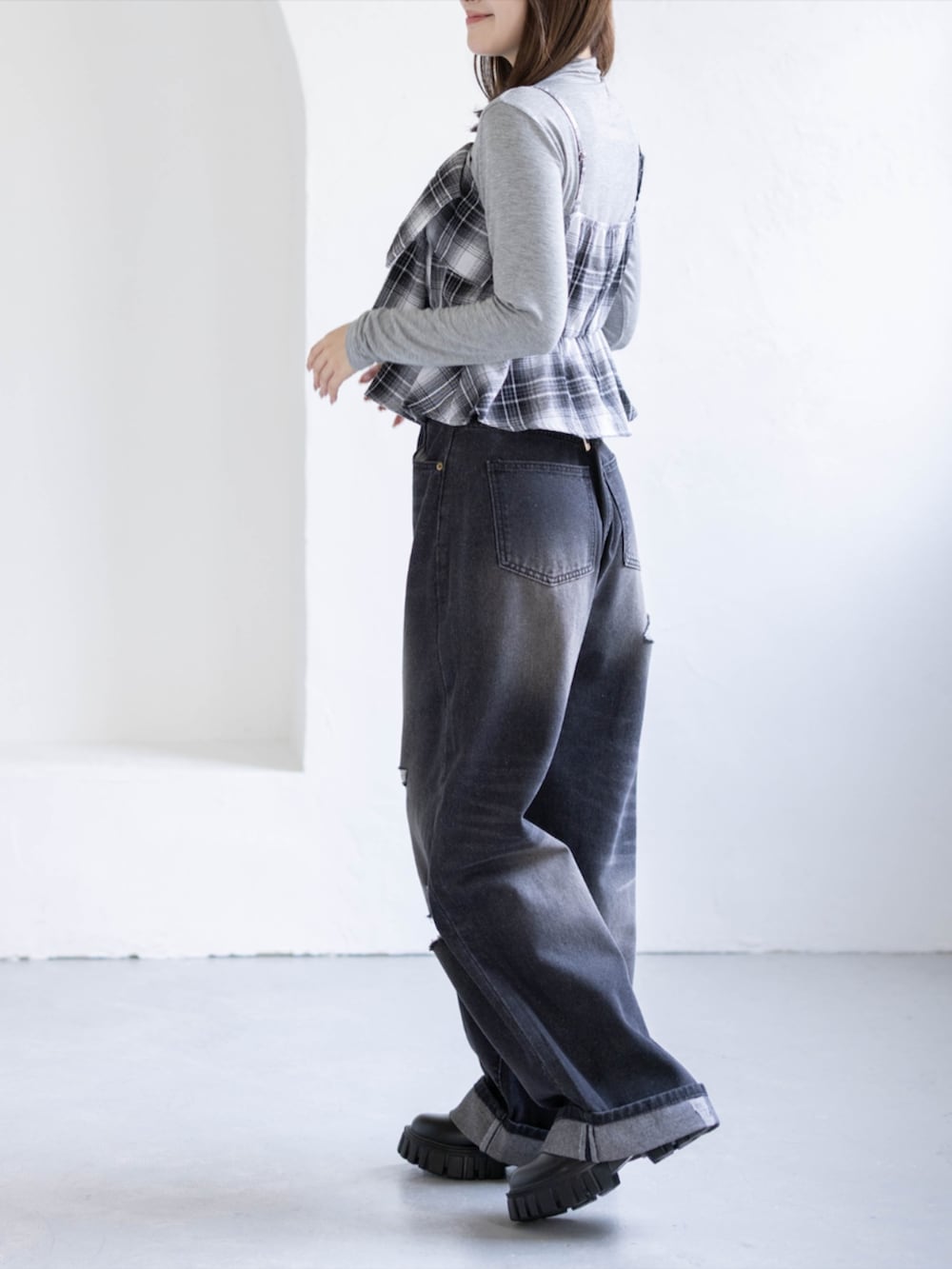 グレー系のTシャツ/カットソー、ブラック系のデニムパンツ、ブラック系のブーツを着用したレディースの秋コーディネートの2枚目の写真