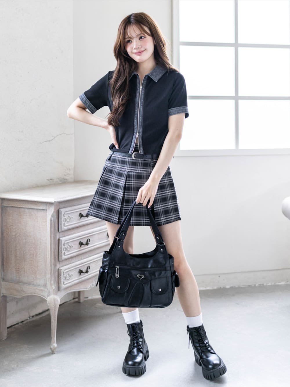 ブラック系のブーツ、ブラック系のTシャツ/カットソー、ブラック系のスカートを着用したレディースの春コーディネートの2枚目の写真