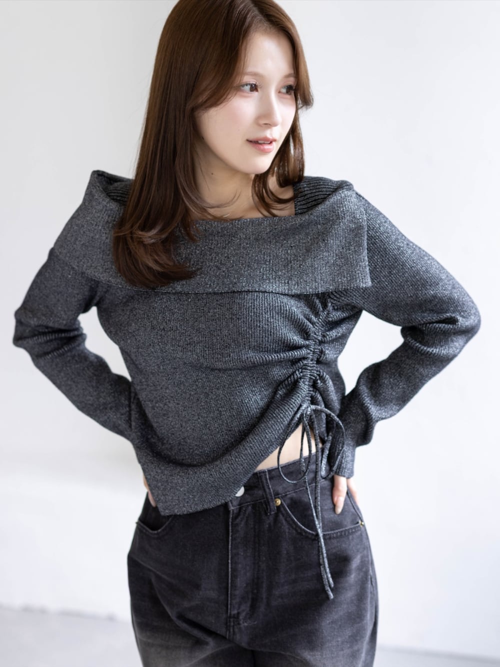 ブラック系のデニムパンツ、ブラック系のブーツ、ブラック系のニット/セーターを着用したレディースの秋コーディネートの5枚目の写真