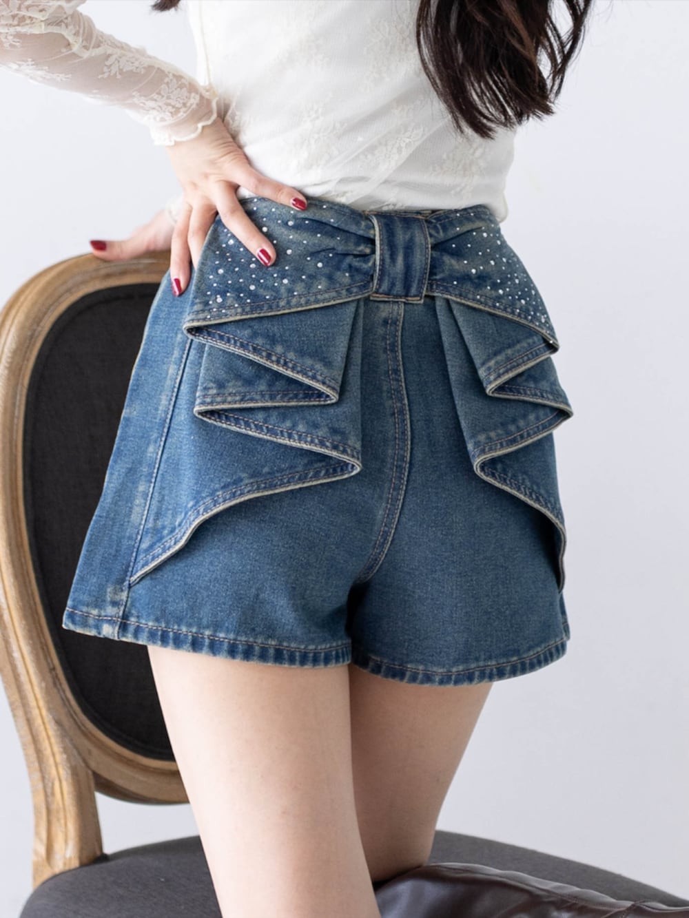 ブルー系のデニムパンツ、ホワイト系のTシャツ/カットソー、ブラウン系のブーツを着用したレディースの秋コーディネートの6枚目の写真