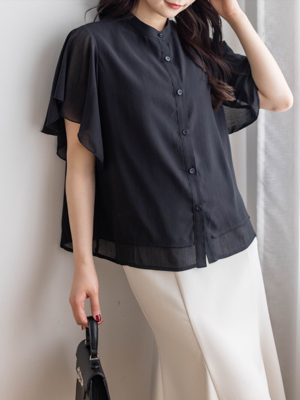 ブラック系のパンプス、ホワイト系のスカート、ブラック系のハンドバッグを着用したレディースの夏コーディネートの9枚目の写真