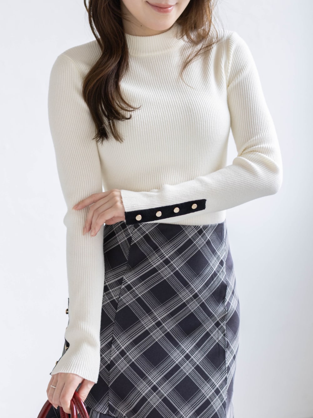 ブラック系のパンプス、ホワイト系のニット/セーター、ブラック系のスカートを着用したレディースの春コーディネートの4枚目の写真