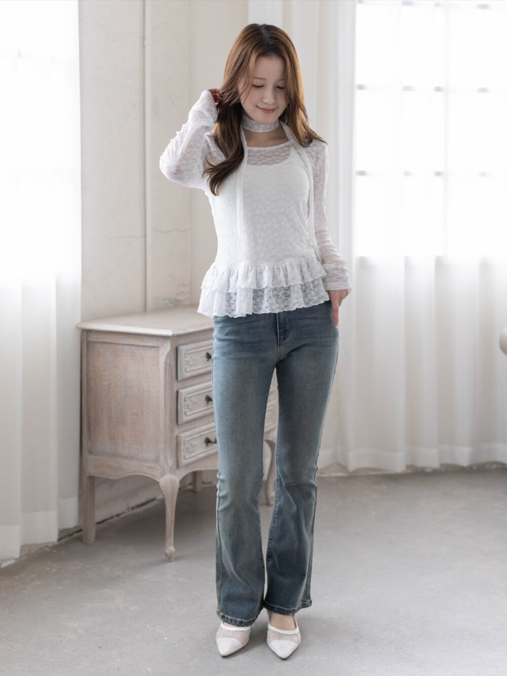 ブルー系のデニムパンツ、ホワイト系のパンプス、ホワイト系のTシャツ/カットソーを着用したレディースの春コーディネートの2枚目の写真