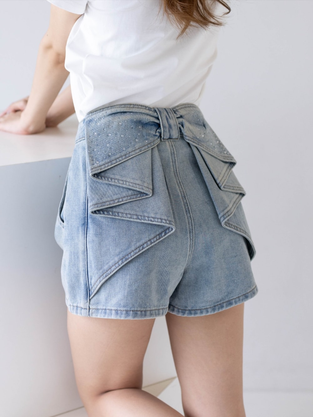 ホワイト系のTシャツ/カットソー、ホワイト系のサンダル、ブルー系のデニムパンツを着用したレディースの夏コーディネートの7枚目の写真