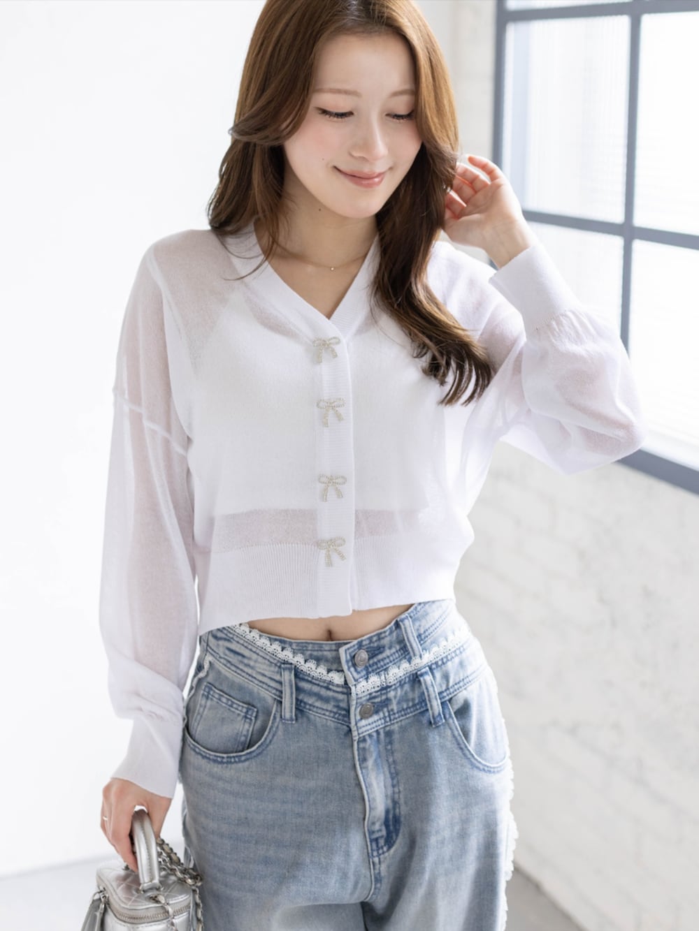 ブルー系のデニムパンツ、ホワイト系のパンプス、ホワイト系のカーディガン/ボレロを着用したレディースの春コーディネートの3枚目の写真