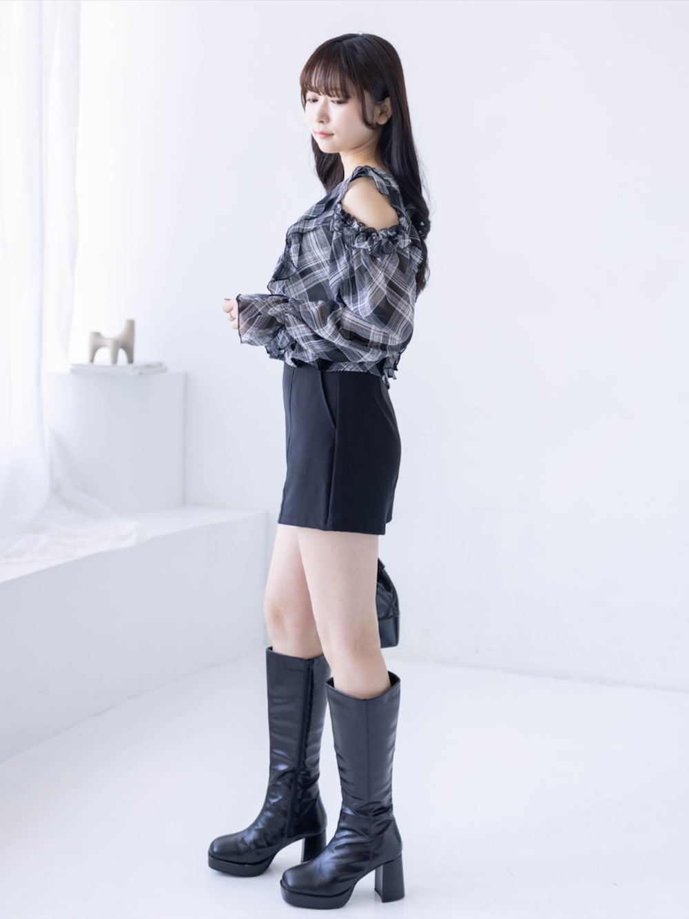 ブラック系のブーツ、ブラック系のその他パンツ、ブラック系のハンドバッグを着用したレディースの夏コーディネートの2枚目の写真