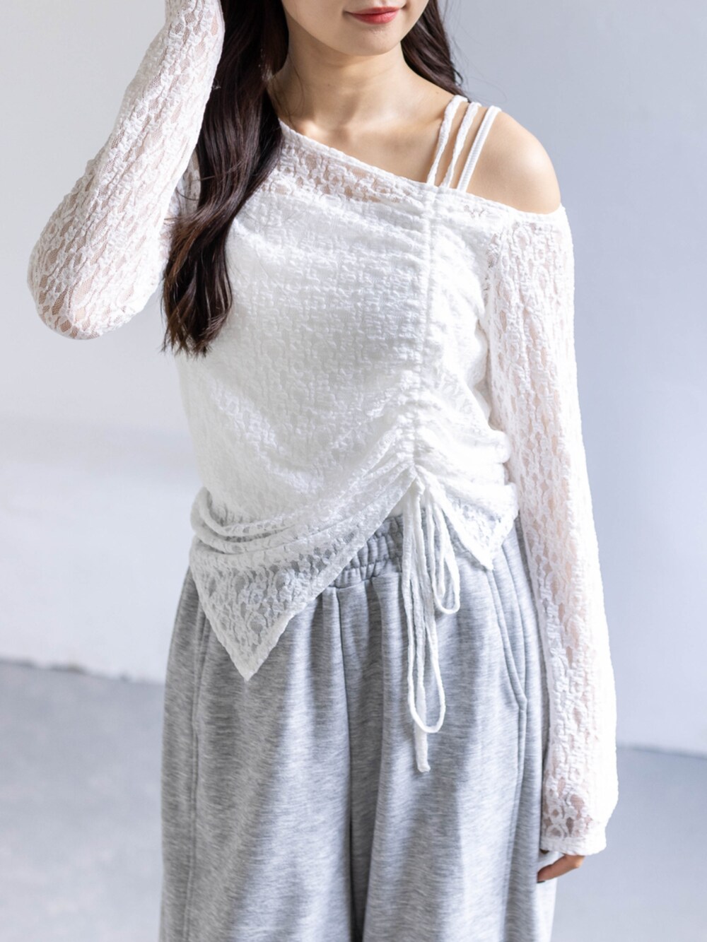 ホワイト系のスニーカー、グレー系のスウェットパンツ、ホワイト系のアンサンブルを着用したレディースの春コーディネートの6枚目の写真