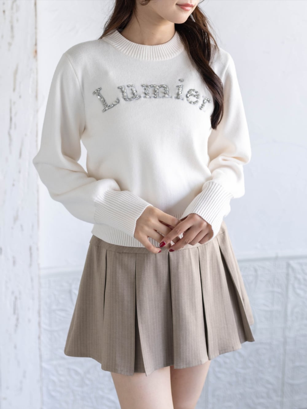 ベージュ系のスカート、イエロー系のパンプス、ホワイト系のニット/セーターを着用したレディースの秋コーディネートの4枚目の写真