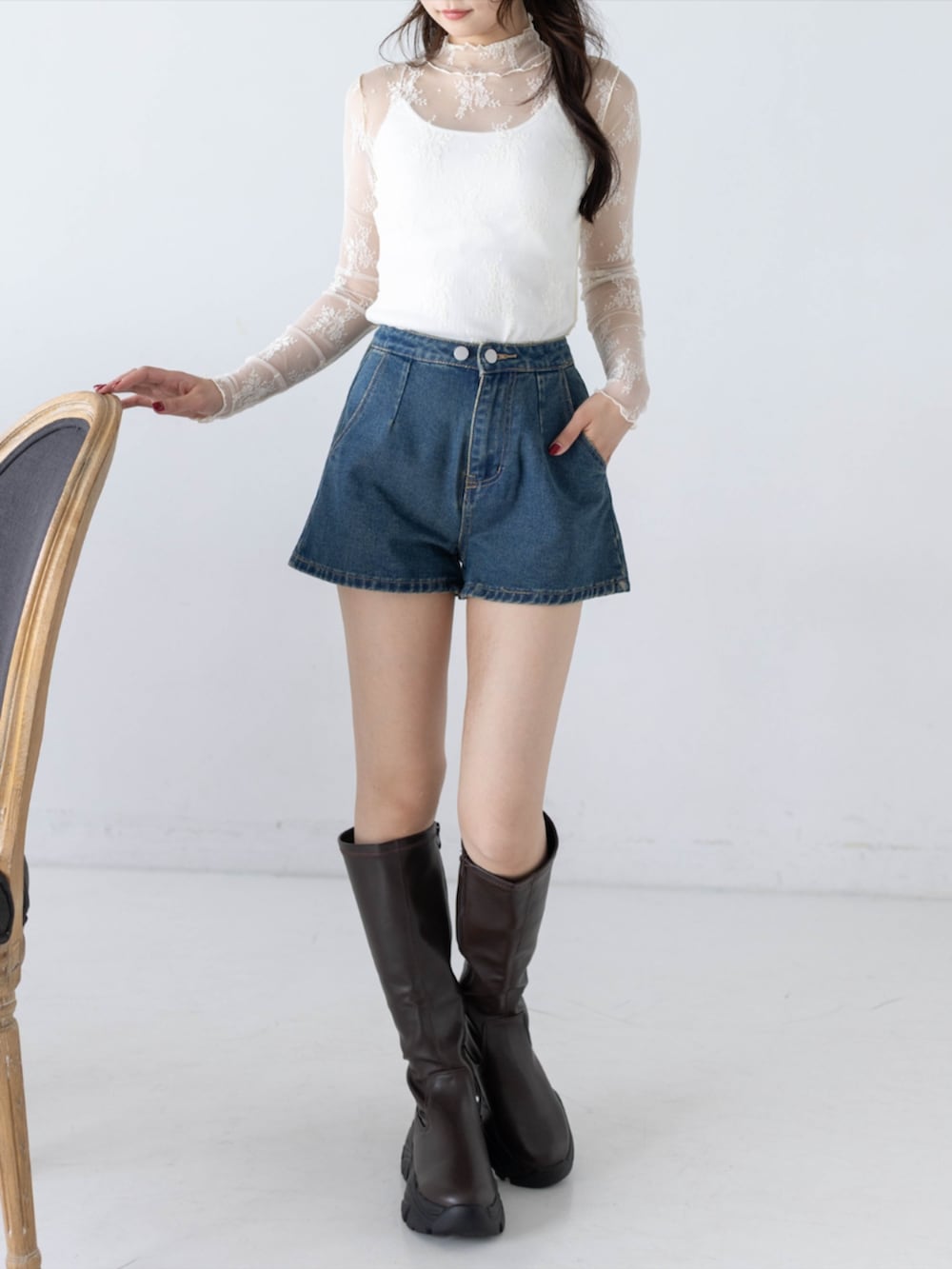 ブルー系のデニムパンツ、ホワイト系のTシャツ/カットソー、ブラウン系のブーツを着用したレディースの秋コーディネートの3枚目の写真
