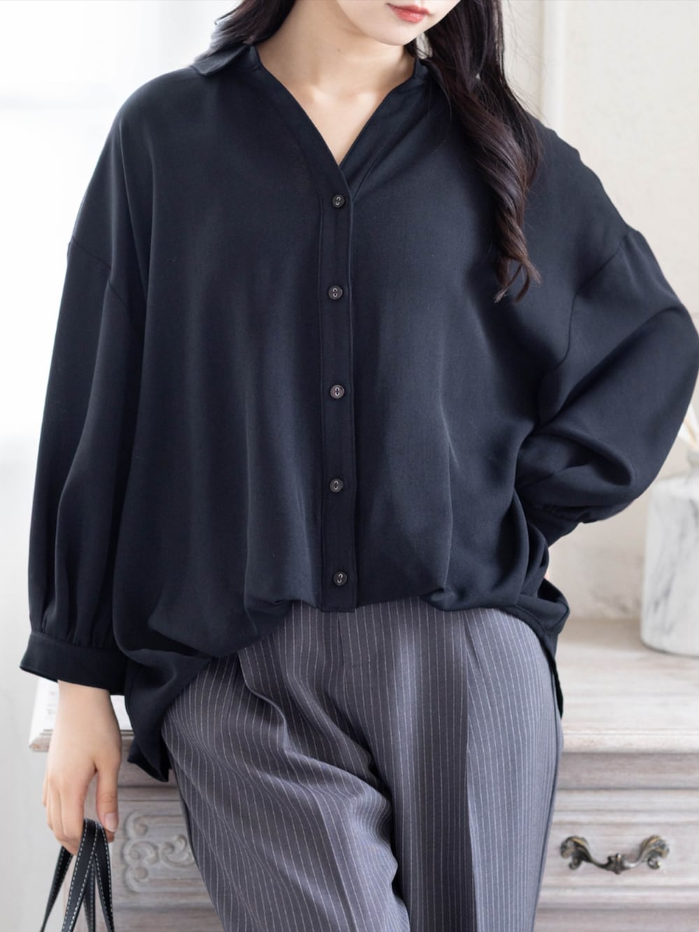 ブラック系のパンプス、グレー系のスラックス、ブラック系のシャツ/ブラウスを着用したレディースの夏コーディネートの2枚目の写真