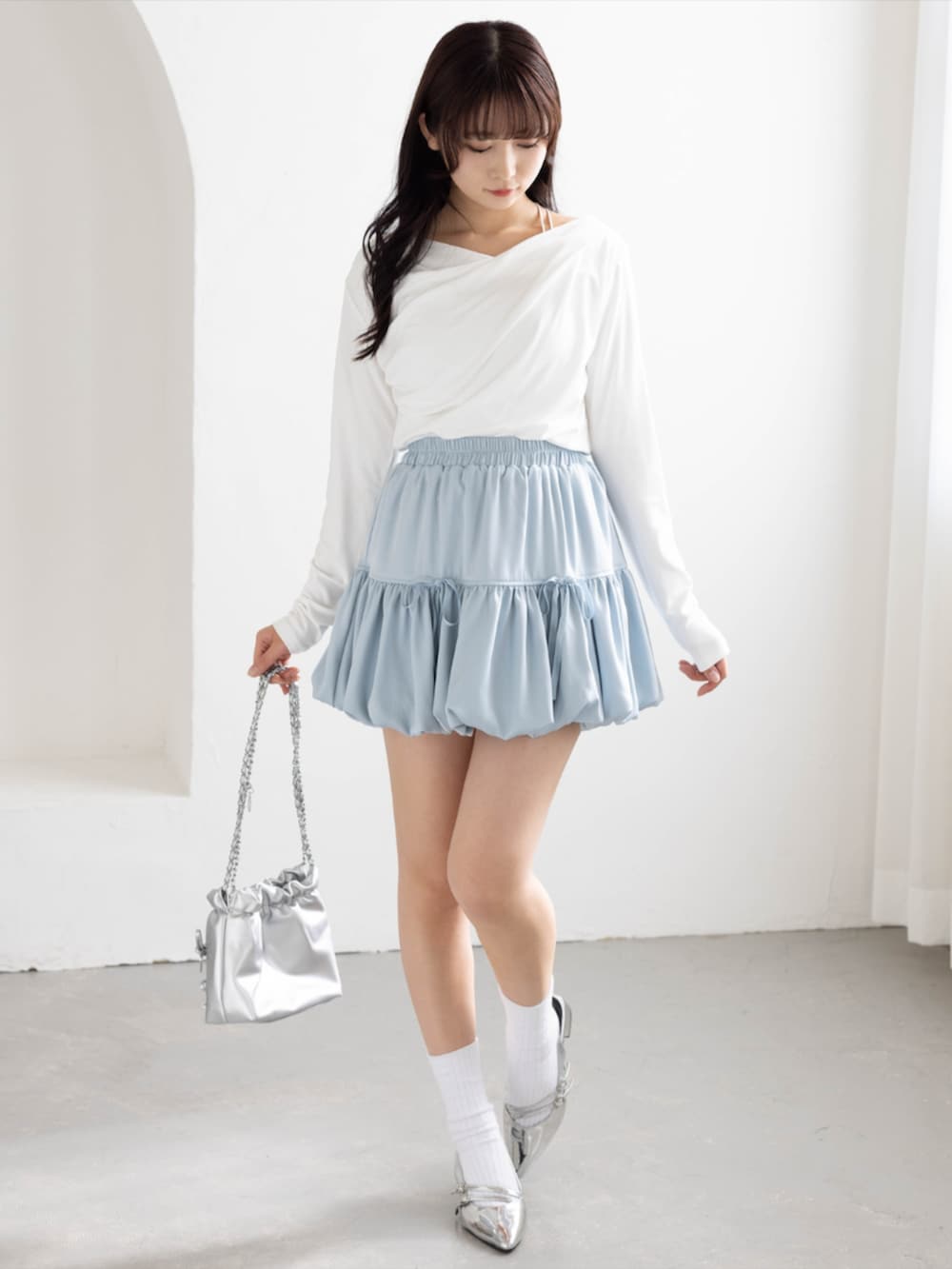 シルバー系のパンプス、ホワイト系のTシャツ/カットソー、ブルー系のスカートを着用したレディースの夏コーディネートの2枚目の写真