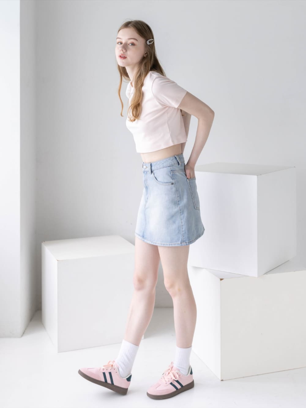 ピンク系のTシャツ/カットソー、ブルー系のデニムスカート、ピンク系のスニーカーを着用したレディースの夏コーディネートの4枚目の写真