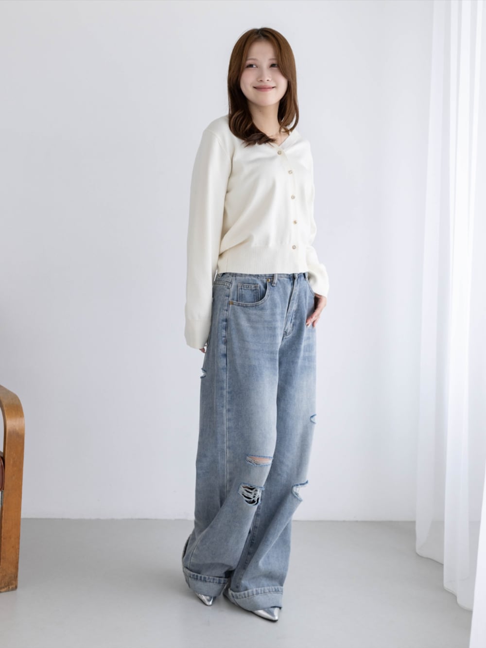 シルバー系のパンプス、ブルー系のデニムパンツ、ホワイト系のカーディガン/ボレロを着用したレディースの秋コーディネートの2枚目の写真
