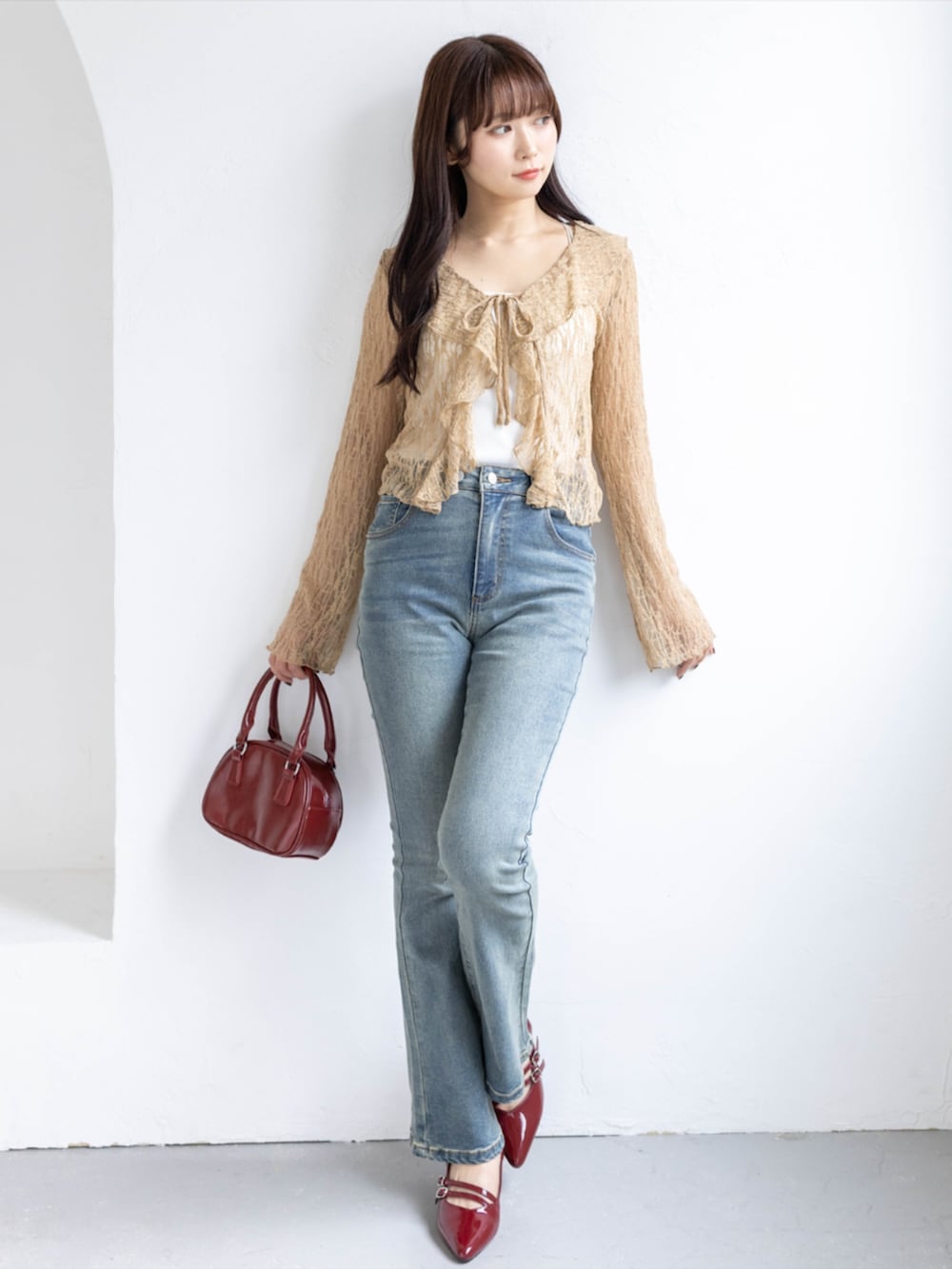 レッド系のパンプス、ブルー系のデニムパンツ、ベージュ系のTシャツ/カットソーを着用したレディースの春コーディネートの2枚目の写真