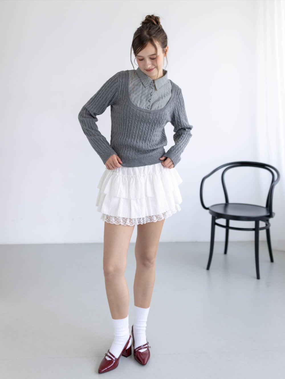 レッド系のパンプス、ホワイト系のスカート、グレー系のニット/セーターを着用したレディースの秋コーディネートの2枚目の写真