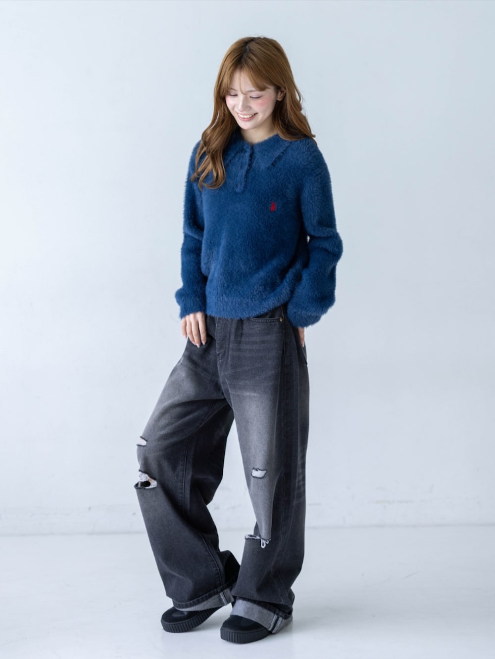 ブラック系のデニムパンツ、イエロー系のスニーカー、ブルー系のニット/セーターを着用したレディースの秋コーディネートの4枚目の写真