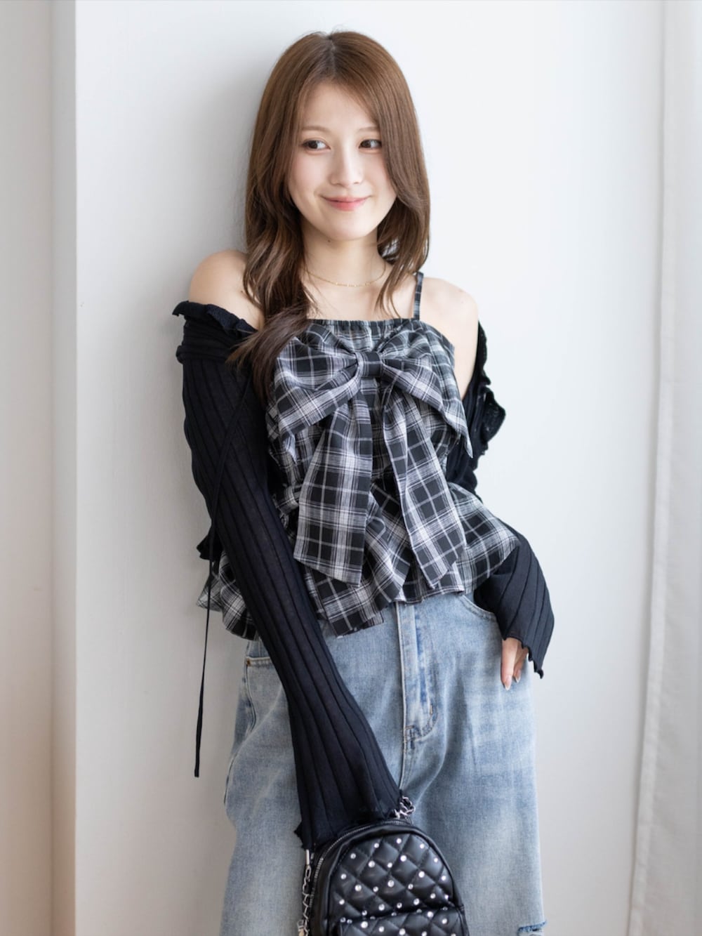 ブラック系のパンプス、ブラック系のカーディガン/ボレロ、ブルー系のデニムパンツを着用したレディースの夏コーディネートの5枚目の写真